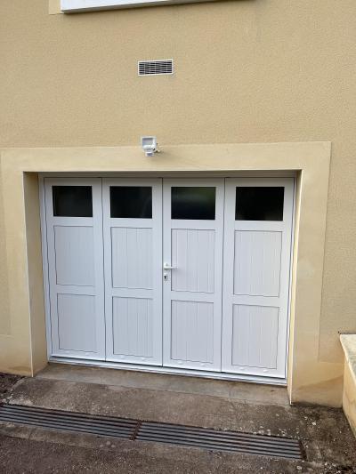 Porte de garage Alu/Pvc , modèle 4 vantaux remplissage panneaux frises verticales avec option partie haute vitrée.
